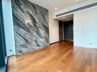 Empty interior space of a building with hardwood floors and a large accent marble wall