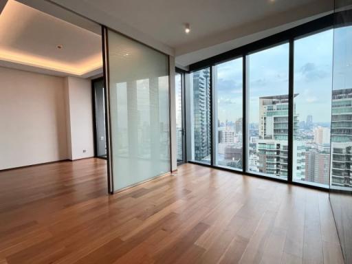 Spacious empty room with large window walls and panoramic city view