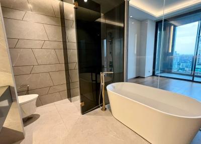 Spacious modern bathroom with freestanding tub, large shower, and city views