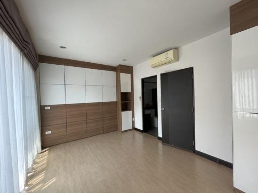 Spacious bedroom with large wardrobe and air conditioning unit