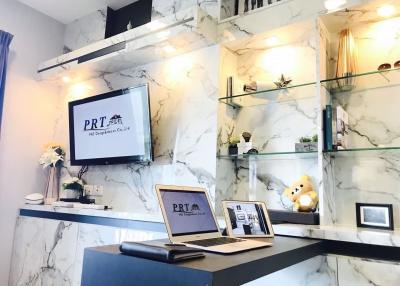 Modern office interior with marble walls, a desk with computer, and decorative elements