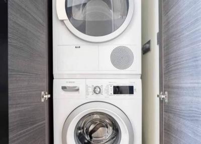 Stacked white Bosch washing machine and dryer in a modern laundry room