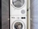 Stacked white Bosch washing machine and dryer in a modern laundry room