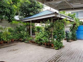 Cozy residential outdoor space with plant-covered pergola and tiled flooring