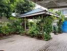 Cozy residential outdoor space with plant-covered pergola and tiled flooring