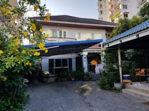 Exterior view of a two-story house with garden and patio