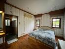 Cozy bedroom with wooden flooring and patterned wallpaper