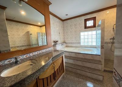 Spacious bathroom with bathtub, dual sinks, and separate shower area