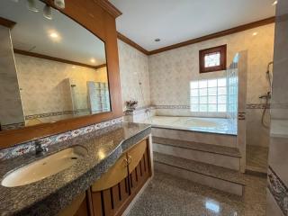 Spacious bathroom with bathtub, dual sinks, and separate shower area