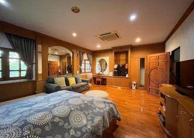 Spacious bedroom with wooden furniture and flooring