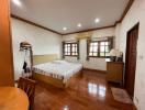 Spacious bedroom with king-sized bed and wooden flooring