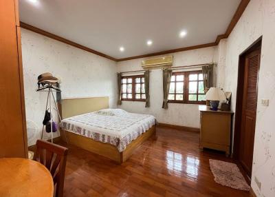 Spacious bedroom with king-sized bed and wooden flooring