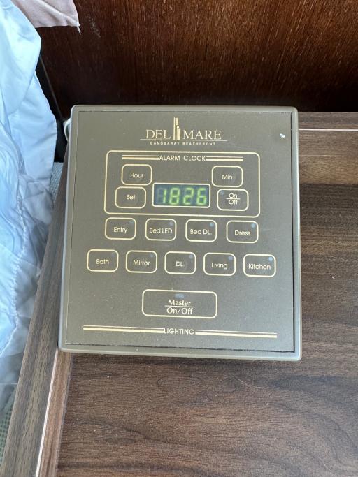 Digital alarm clock on a wooden bedside table in the bedroom