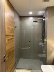 Modern bathroom with glass shower enclosure and wooden accents