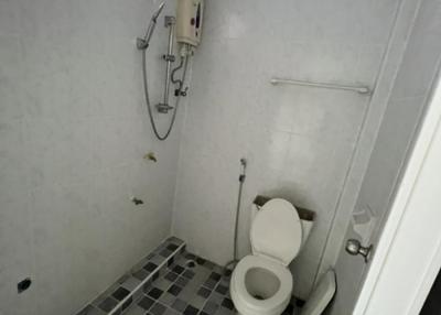 Compact bathroom with white walls and patterned floor tiling