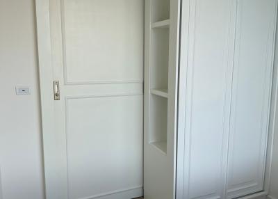 Modern bedroom with sleek white wardrobe and wooden floor
