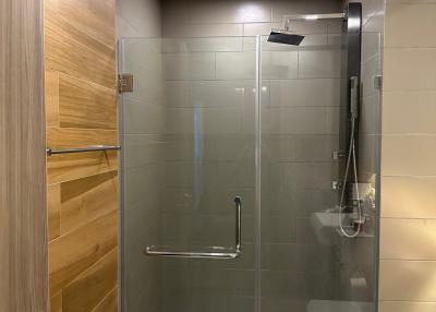 Modern bathroom with glass shower enclosure and wooden accents