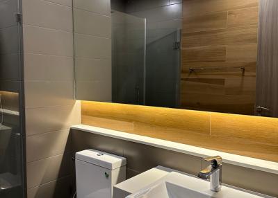Modern bathroom interior with wall-mounted sink, toilet, and glass shower area
