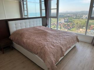 Modern bedroom with large windows boasting an ocean view