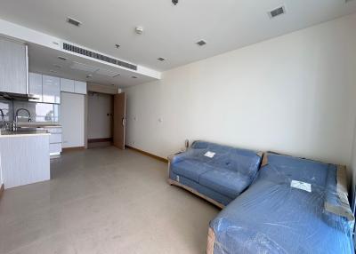 Spacious open plan living room with adjacent kitchen area and large windows