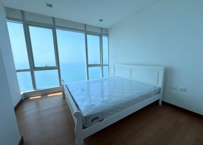 Spacious bedroom with a large bed and panoramic windows overlooking the sea