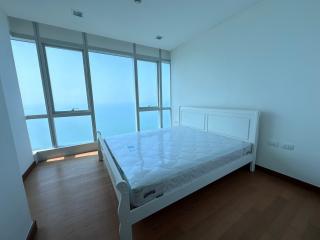 Spacious bedroom with a large bed and panoramic windows overlooking the sea