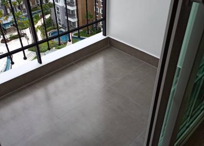 Compact balcony with tiled floor and metal railing overlooking other apartment buildings