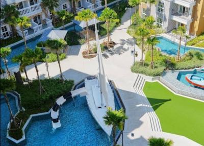 Aerial view of upscale outdoor common area with swimming pool and palm trees