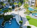 Aerial view of upscale outdoor common area with swimming pool and palm trees