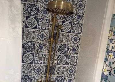 Elegant bathroom with detailed blue and white tilework and vintage style shower fixtures
