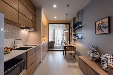 Modern open plan kitchen with adjacent cozy living space and abundant natural light