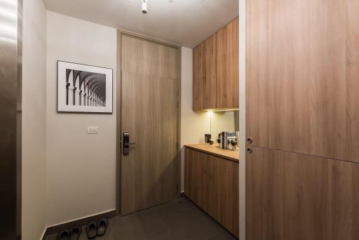 Modern entrance hall with wooden wardrobe and artwork