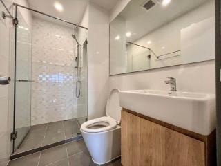 Modern bathroom with glass shower enclosure and wooden cabinet