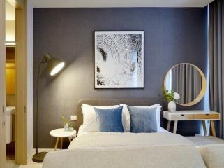 Modern bedroom interior with comfortable bedding, accent pillows, and decorative elements