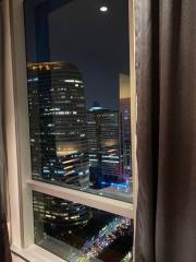 View from the bedroom window at night showcasing the cityscape and moon