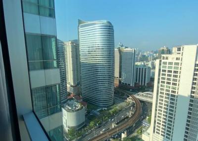 Cityscape view from a high-rise building, showing surrounding buildings and streets