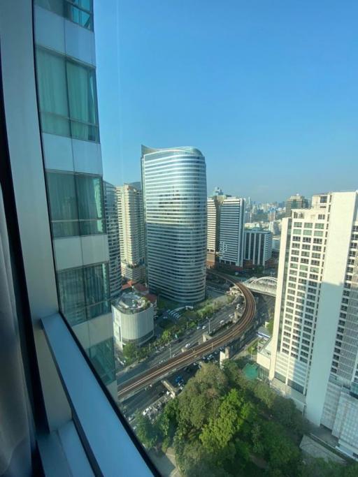 Cityscape view from a high-rise building, showing surrounding buildings and streets