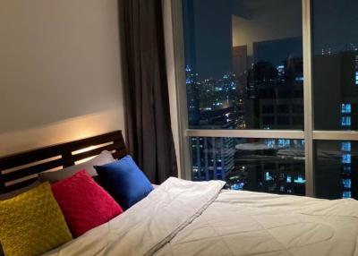 Cozy bedroom with large window city view at night