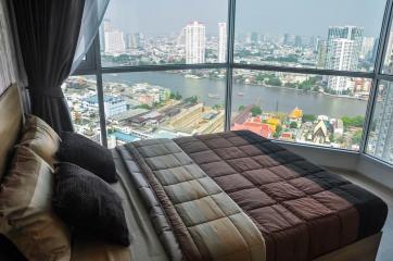 Modern bedroom with a view of the city skyline and river