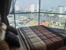 Modern bedroom with a view of the city skyline and river