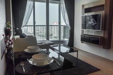 Modern living room with balcony access featuring contemporary furniture and city views