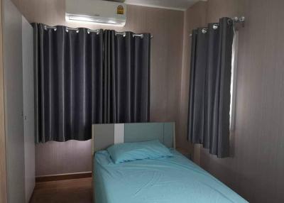 Cozy bedroom with modern air conditioning unit and dark curtains