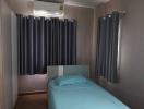 Cozy bedroom with modern air conditioning unit and dark curtains