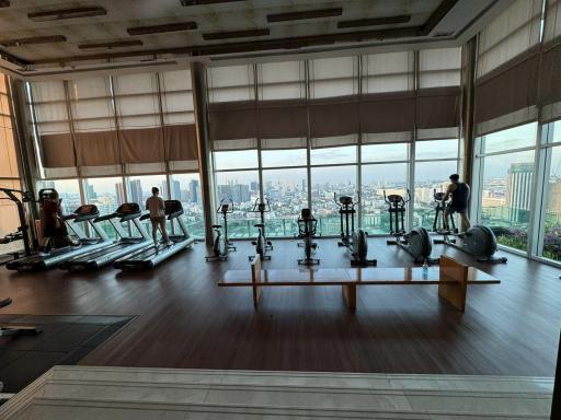 Modern high-rise gym with panoramic city views and multiple exercise machines