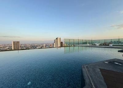 Infinity pool with a panoramic city view at dusk