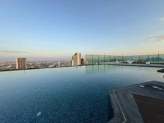 Infinity pool with a panoramic city view at dusk