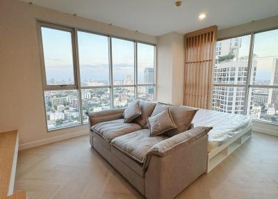 Spacious living room with large windows, city view, and plenty of natural light