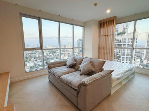 Spacious living room with large windows, city view, and plenty of natural light
