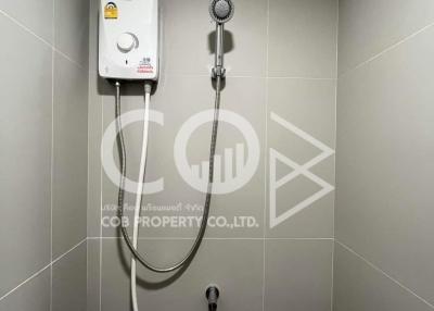 Modern bathroom with wall-mounted water heater and handheld shower