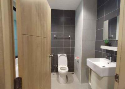 Modern bathroom with wooden cabinets and grey tiles